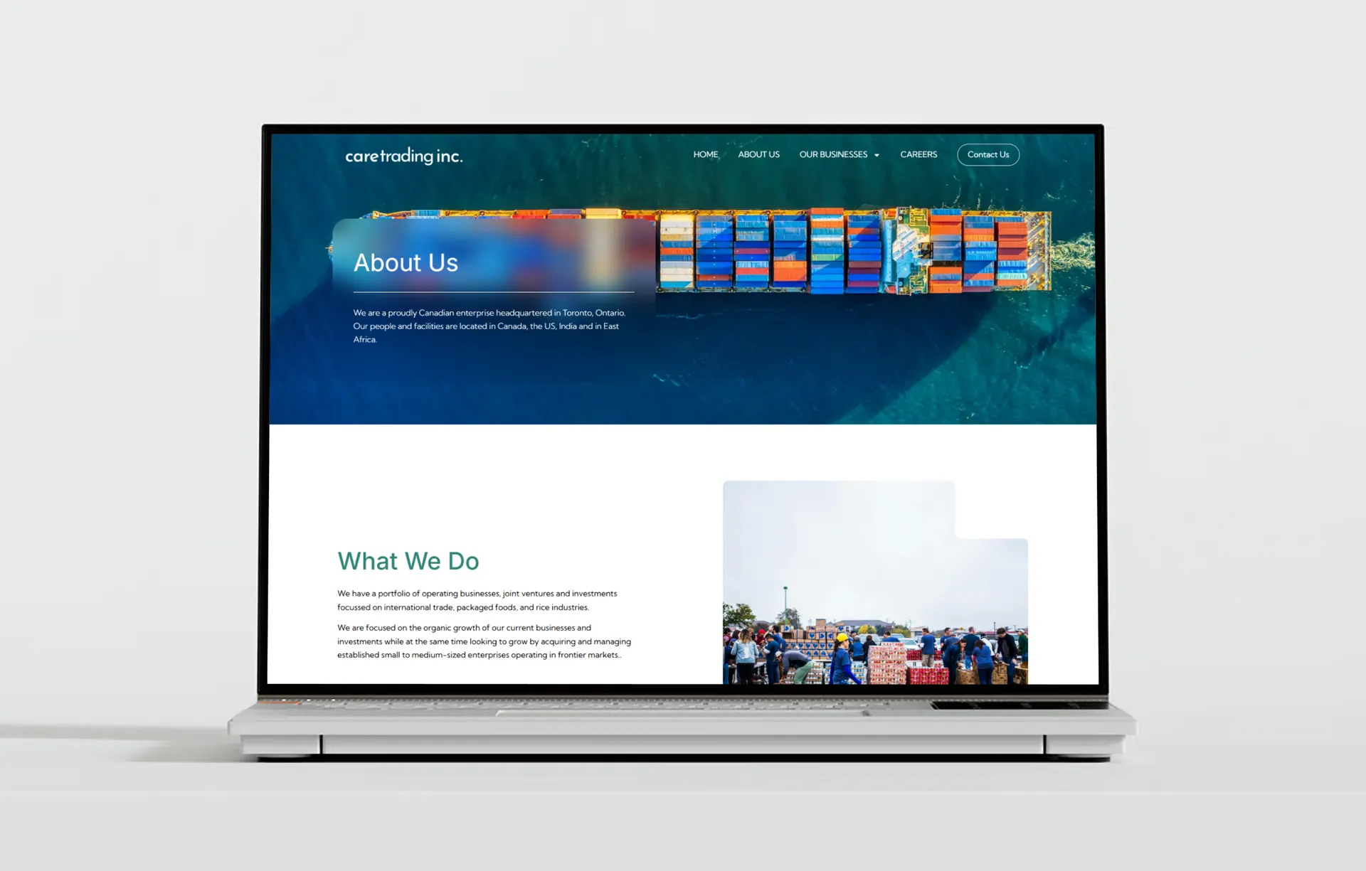 A laptop showing the About Us page, with the heading over an aerial photo of a container ship and a What We Do section underneath.