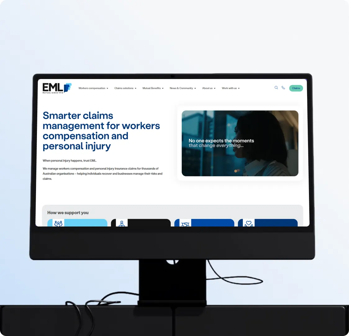 A desktop monitor showing the EML home page, with the how we support you row starting below the fold.